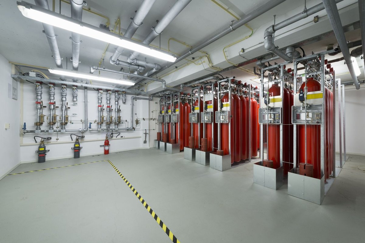 Worker spraying red firestop sealant
